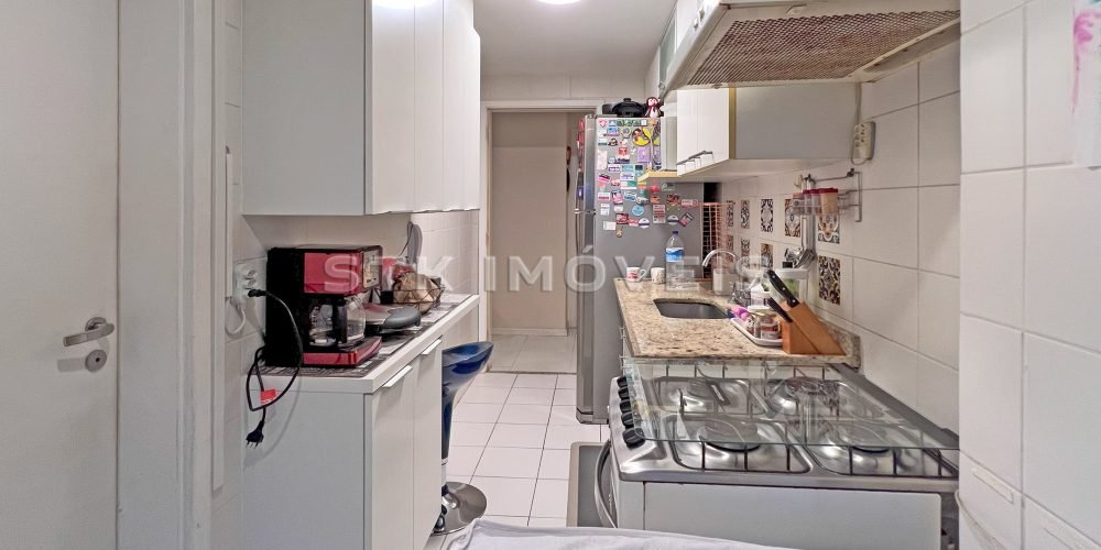 a kitchen with white cabinets and appliances